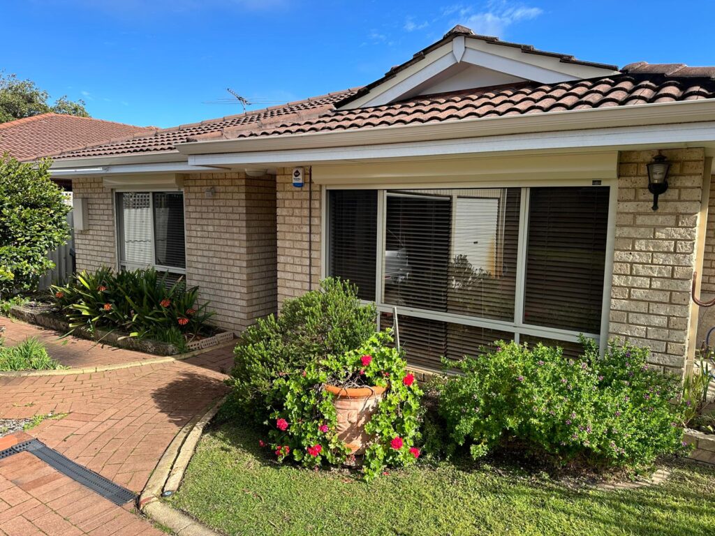 Perth brick home with cream roller shutters-manual vs electric options suit different window sizes.