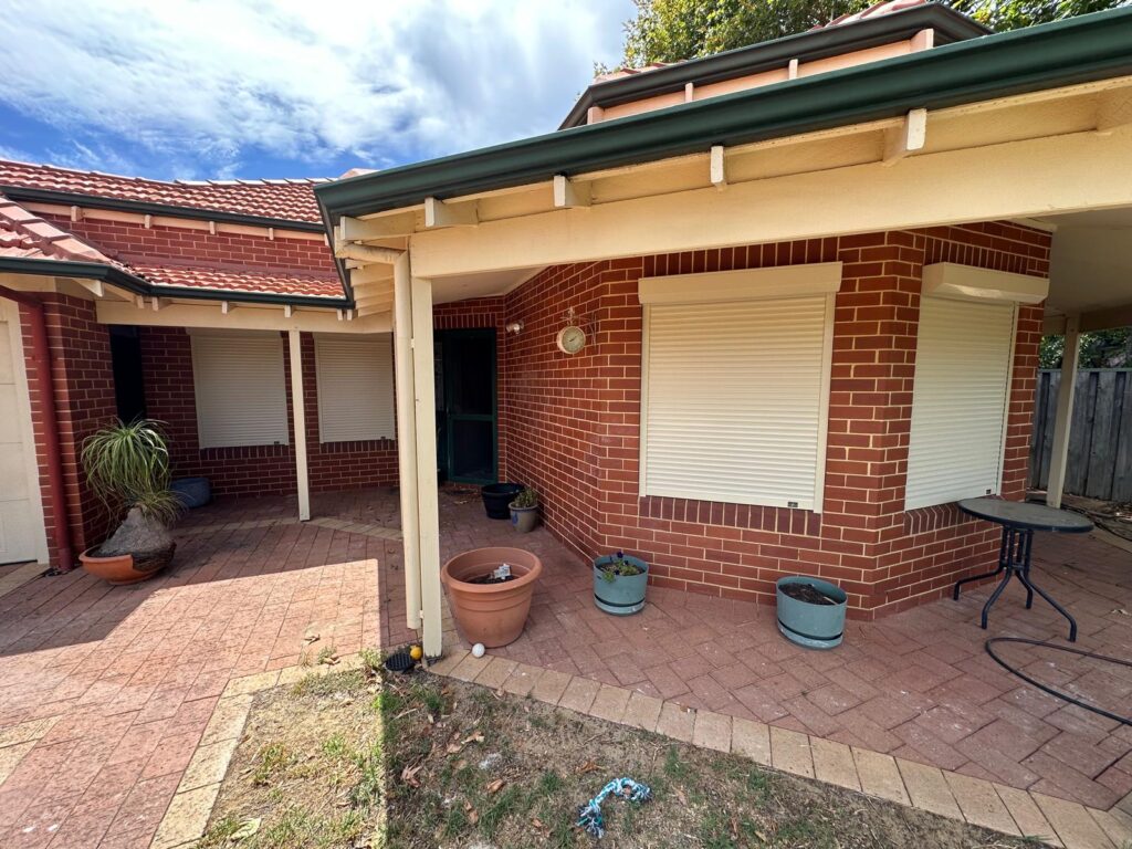 Cream roller shutters on a brick Perth home